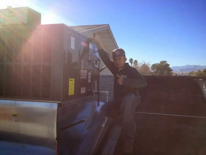HVAC technician performing HVAC Inspection on a rooftop unit in Carthage